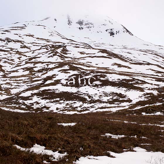Melt by Michael Cross. Giant letters acb made of smow on a hillside.